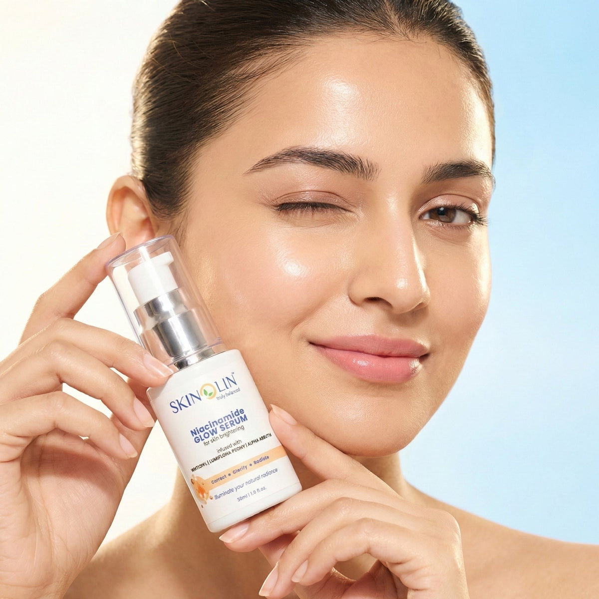 Woman holding Skinolin Niacinamide Glow Serum to her cheek