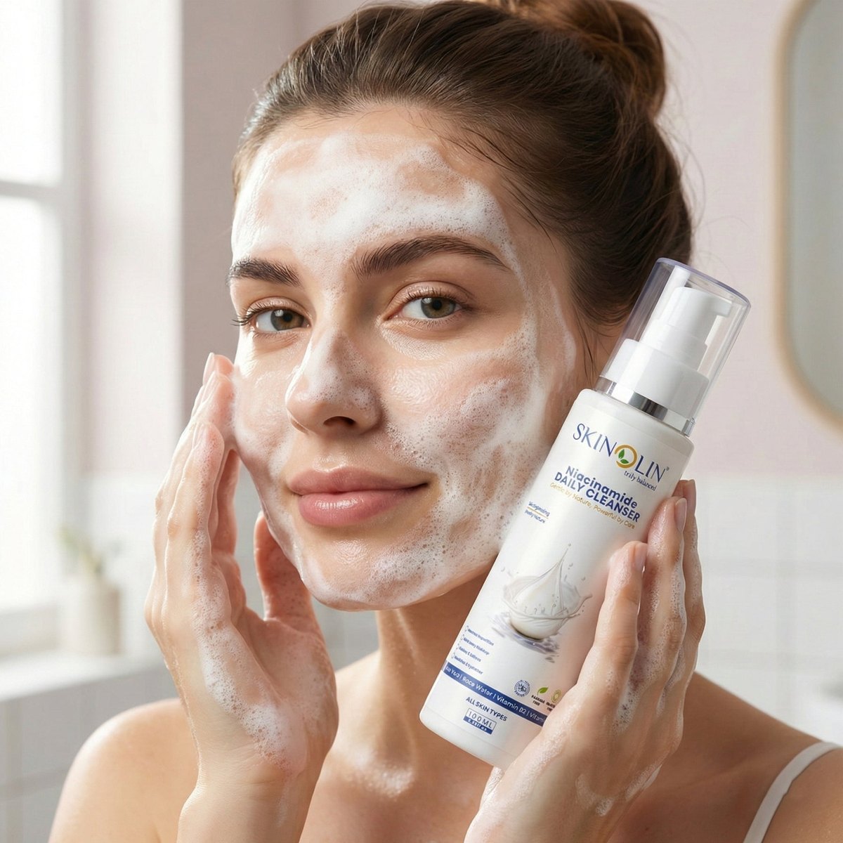 Woman with lather on her face holding the Skinolin Niacinamide Daily Cleanser