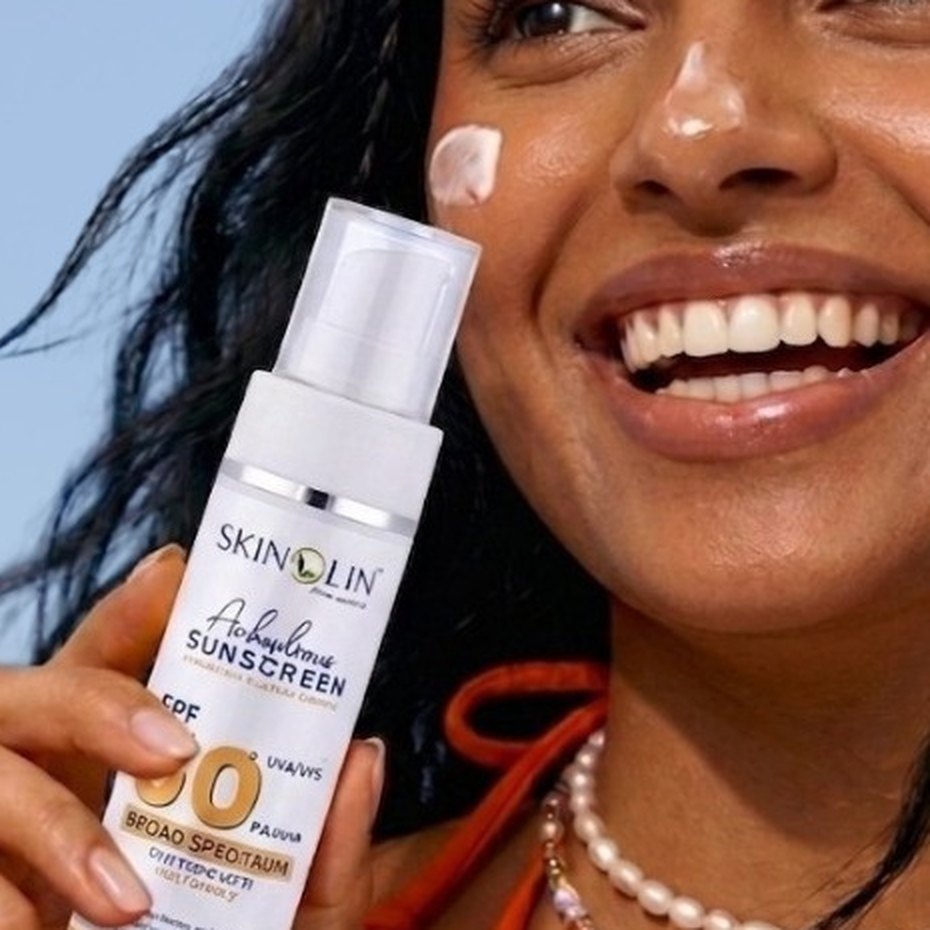 Woman holding Skinolin Anhydrous Sunscreen SPF 50 with sunscreen dotted on her cheek