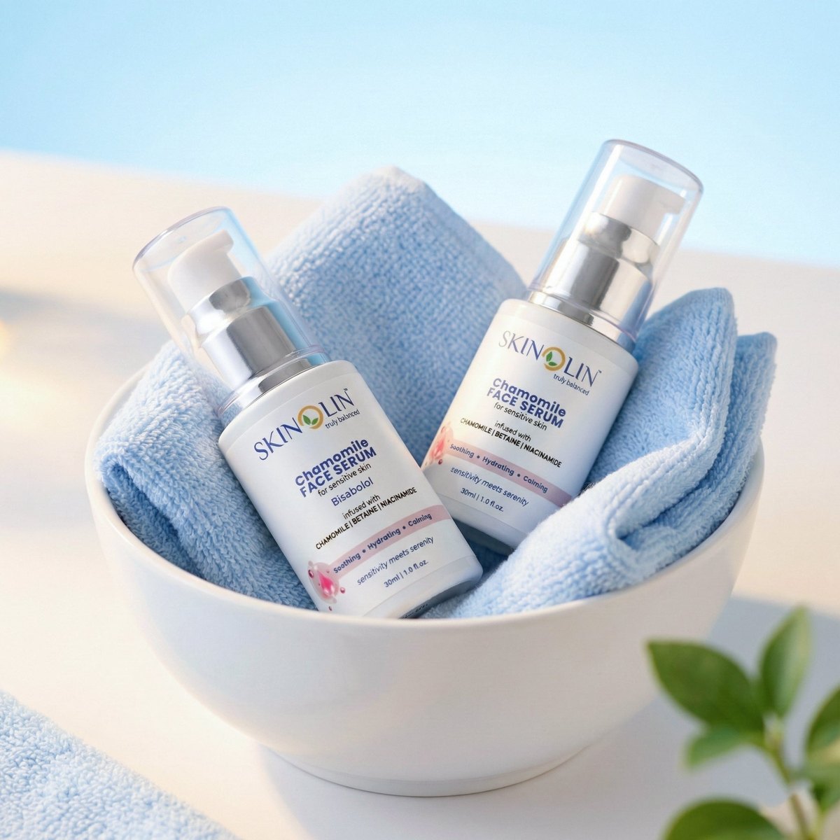 Two Skinolin face serums in a white bowl with a soft folded towel